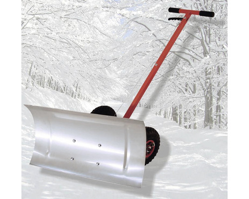 Chasse-neige à roues avec poignée rouge devant un paysage enneigé