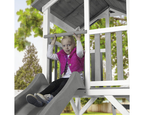 Mädchen auf einem Spielturm mit Rutsche und Kletterstange