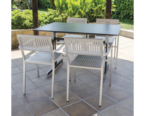 Table de jardin avec quatre chaises de jardin sur une terrasse
