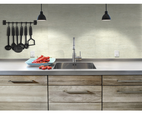 Küchenspüle mit Armatur, Küchenutensilien und Gemüse auf einer Arbeitsplatte.