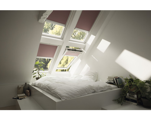 Chambre mansardée lumineuse avec lit et fenêtres de toit avec stores enrouleurs
