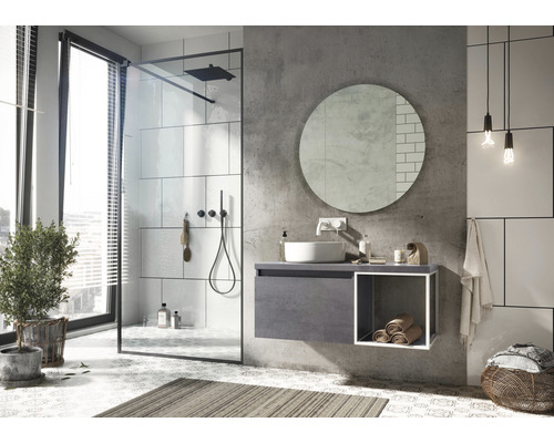 Helles Badezimmer mit Dusche, Waschtisch, Spiegel und Dekorationen.