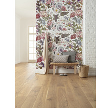 Pièce lumineuse avec papier peint floral, plancher en bois, banc et décorations.