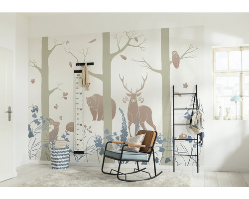 Kinderzimmer mit Waldtiermotiven an der Wand, einem schwarzen Regal, einem Schaukelstuhl und einer Messlatte.