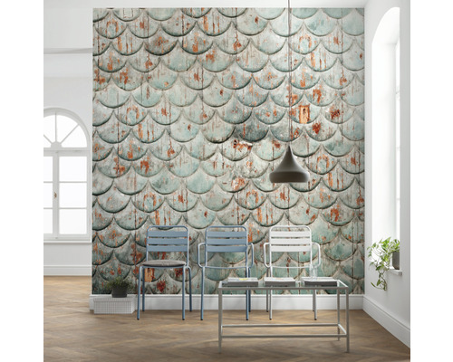 Dekoratives Interieur mit Wandtapete in Fischschuppenoptik, Stühlen und Beistelltisch.