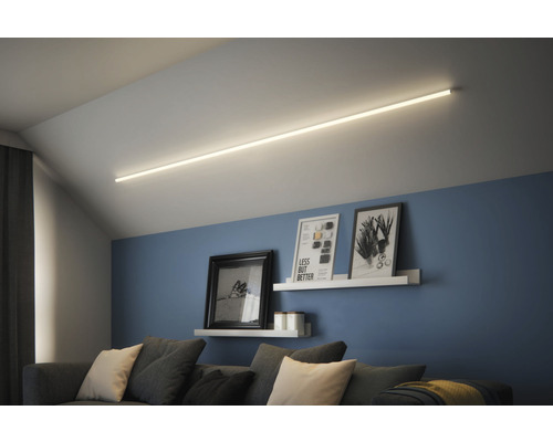 Wohnzimmer mit linearem Deckenlicht, Sofa und Wandregalen mit Bildern