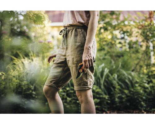 Femme dans le jardin avec un sécateur.