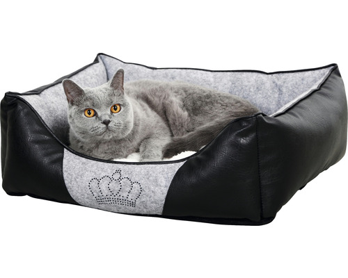 Katze liegt in einem schwarzen Katzenbett mit Kronenmuster