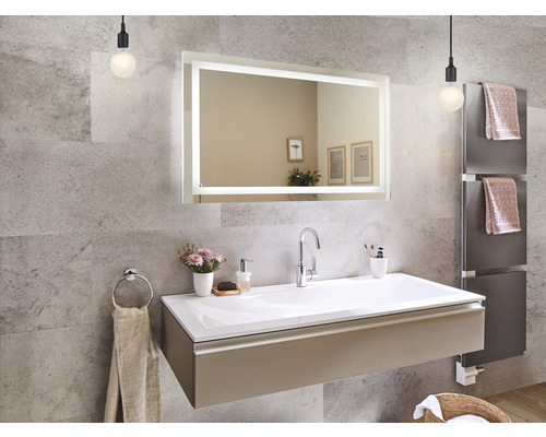 Badezimmer mit Waschtisch, beleuchtetem Spiegel und Handtuchwärmer