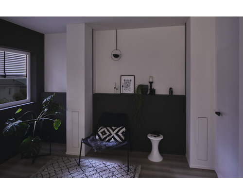 Wohnzimmer mit Sessel, Beistelltisch, Zimmerpflanze und Dekoration