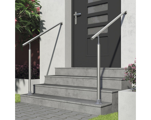 Escalier avec rampe en acier inoxydable devant une porte d''entrée.