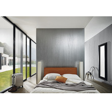 Chambre lumineuse avec lit, valise et grande fenêtre donnant sur la verdure