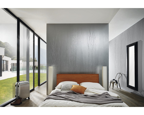 Chambre lumineuse avec lit, valise et grande fenêtre donnant sur la verdure