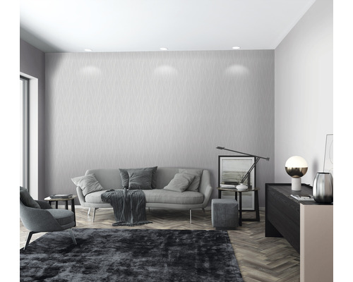 Modernes Wohnzimmer mit grauer Couch, Sessel und gemusterter Tapete