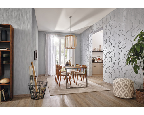 Salle à manger moderne avec papier peint à motifs, table en bois et chaises.