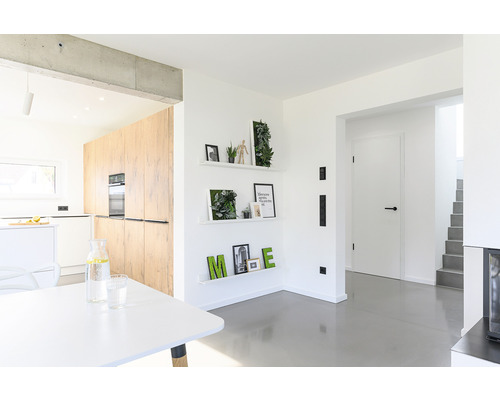 Heller Raum mit Küche, Regalen und Esstisch