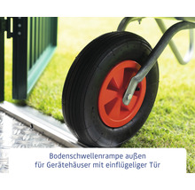 Rad einer Schubkarre auf einer Bodenschwellenrampe vor einem Gartentor