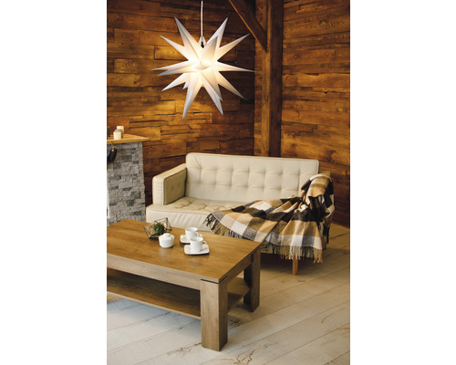 Wohnzimmer mit Sofa, Tisch und beleuchtetem Stern