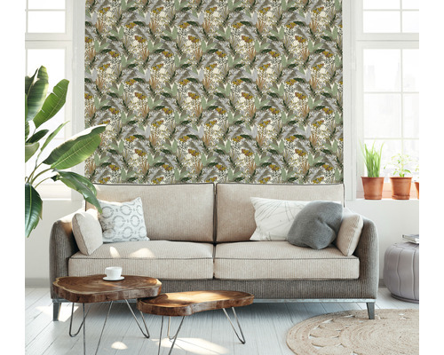 Un salon avec un canapé et un revêtement mural avec des motifs végétaux.