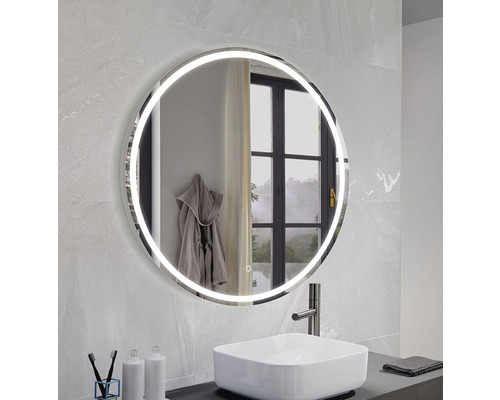 Badezimmer mit rundem Spiegel mit Beleuchtung über einem Waschbecken.