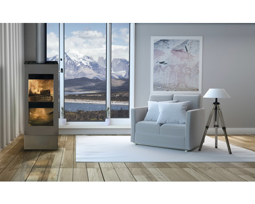 Salon avec poêle à bois, canapé et lampe devant une fenêtre avec vue sur la montagne