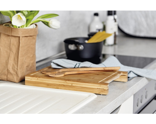 Küchenszene mit Schneidebrett, Kochtopf und Utensilien