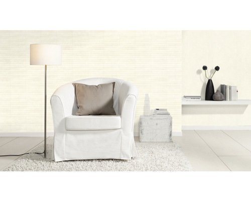 Salon lumineux avec fauteuil, lampadaire et étagère murale