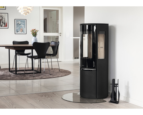 Salon avec poêle à bois, table à manger et chaises.