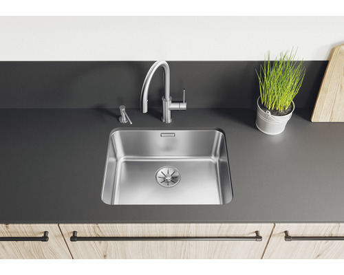 Küchenszene mit Spüle, Armatur, Seifenspender und Dekoration auf einer Arbeitsplatte