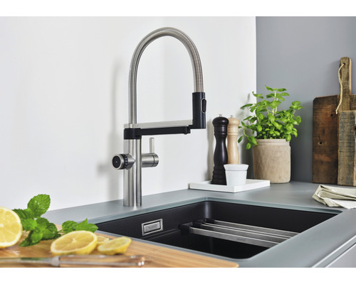 Scène de cuisine avec robinet d''évier, évier et accessoires.