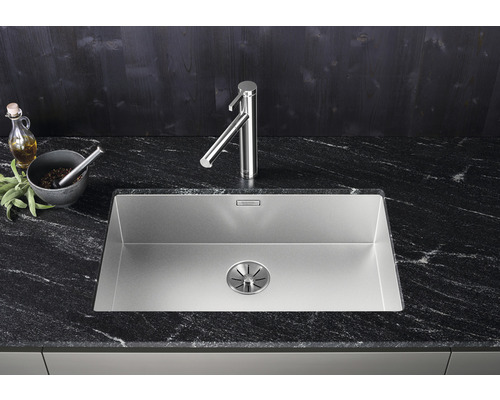 Edelstahlspüle mit Armatur auf einer dunklen Arbeitsplatte