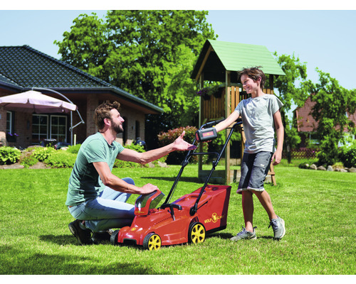 Vater und Sohn mit Akku Rasenmäher im Garten