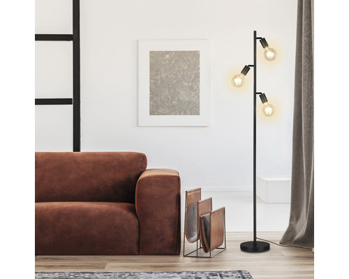 Wohnzimmer mit Stehlampe, Sofa und Zeitschriftenständer