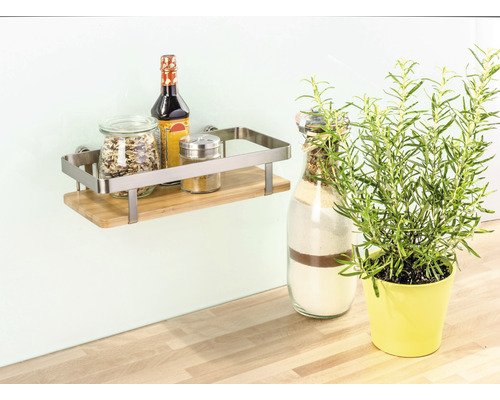 Wandregal mit Gewürzen und Kräutertopf auf einem Holztisch