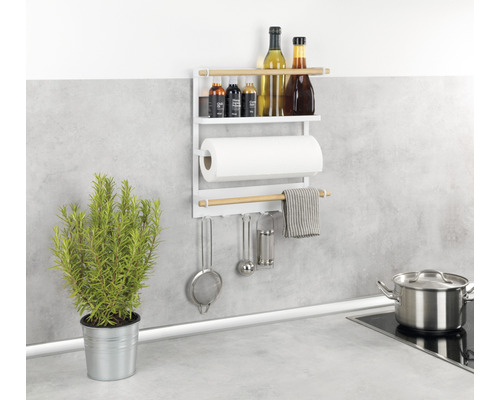 Küchenszene mit weißem Wandregal, Küchenrolle, Kochutensilien und Kräutertopf