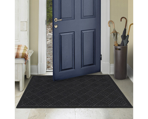Paillasson noir devant une porte ouverte