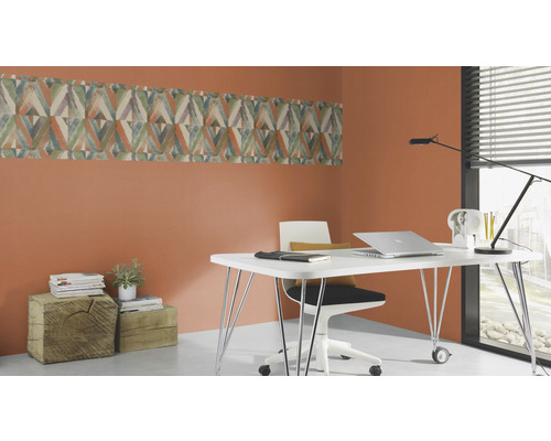 Büro mit Schreibtisch, Stuhl und Wandbordüre mit geometrischem Muster