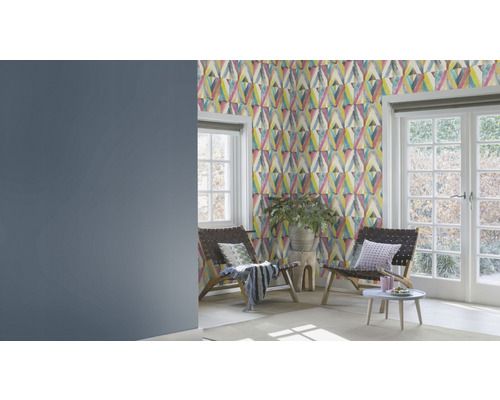 Wohnzimmer mit gemusterter Tapete, zwei Sesseln und Fenster zum Garten