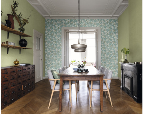 Salle à manger avec table, chaises, papier peint à motifs végétaux et étagères en bois