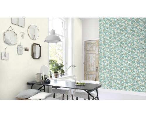 Salle à manger avec papier peint à motifs floraux, table à manger et miroirs au mur.