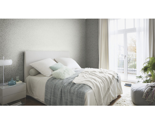 Chambre à coucher avec lit, table de chevet et papier peint à motifs