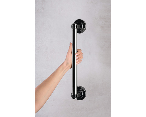 Person hält einen Haltegriff für das Badezimmer.