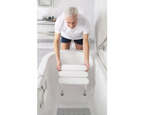 Mann setzt einen Badewannensitz in eine Badewanne für mehr Komfort und Sicherheit