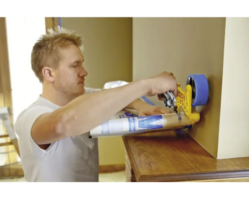 Un homme utilise un rouleau à peinture pour peindre un mur.