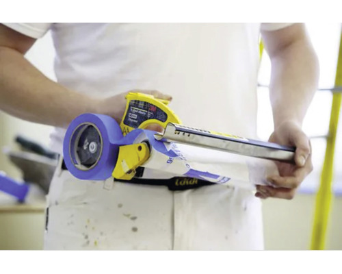 Personne tenant un applicateur de ruban de masquage avec du ruban adhésif de peintre