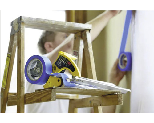 Scène avec dérouleur de ruban de masquage, ruban de masquage et échelle lors de travaux de peinture