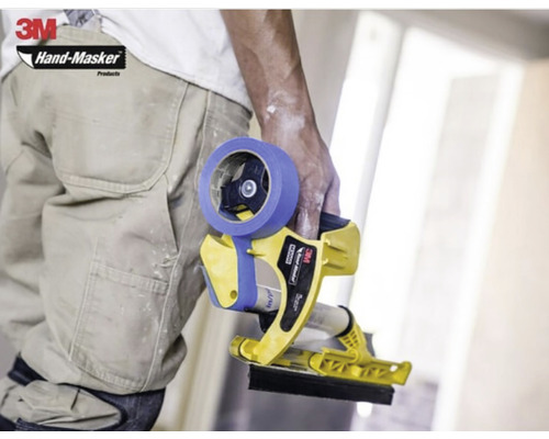 Un artisan tient un appareil de masquage manuel 3M Hand-Masker avec du ruban de masquage