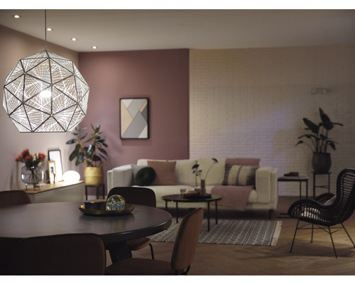 Wohnzimmer mit Esstisch, Sofa und geometrischer Pendelleuchte