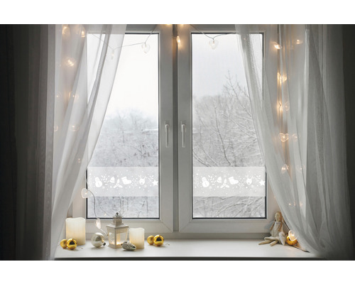 Dekoriertes Fenster mit Fensterfolie, Vorhängen und Weihnachtsdekoration.