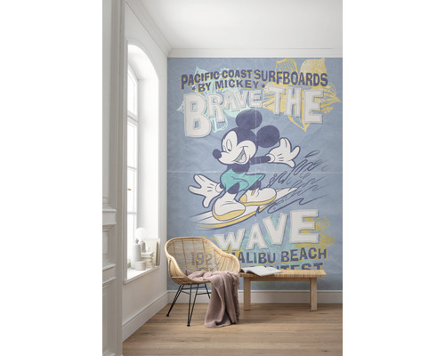 Pièce avec un papier peint photo représentant Mickey Mouse surfant sur une vague, avec le texte Pacific Coast Surfboards.